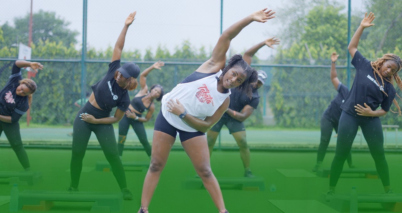 Coach Uduak leading a stretch with her Tabata class outdoors